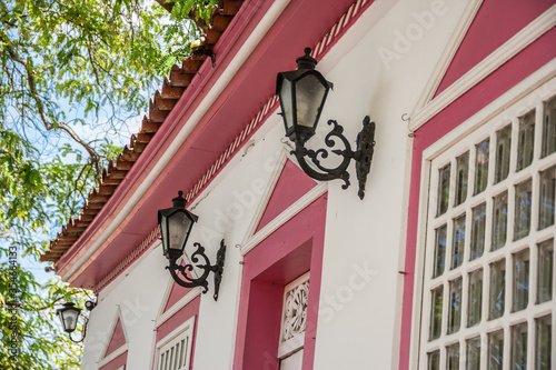 Detalhe de fachada de casario na cidade de Pirenópolis em Goiás. Telhado, luminárias e janelas.