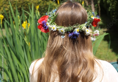 Dziewczyna w wianku z polnych kwiatów na głowie
