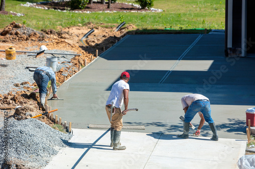 Unidentifiable Hispanic men working on a new concrete driveway