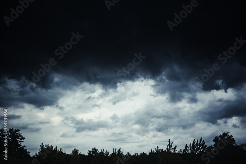 Fototapeta w ciemne chmury i las
