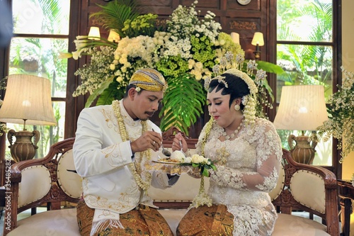 Dulangan ceremony on javanese wedding is a sign that the couple will help and love each other until grey and old by feeding each other three times.