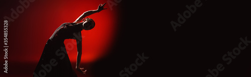 panoramic orientation of young woman dancing flamenco on red and black