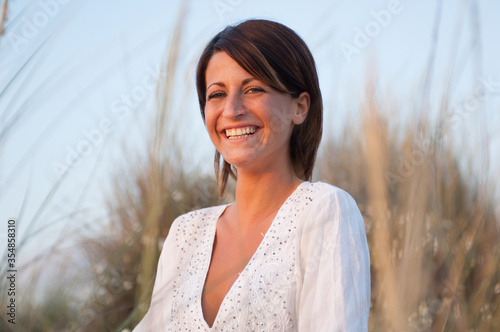 Ritratto di una giovane donna vestita di bianco sorridente