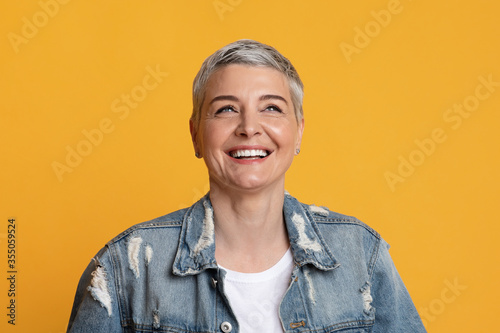 Positive Emotions. Closeup of happy stylish mature woman looking away and laughing