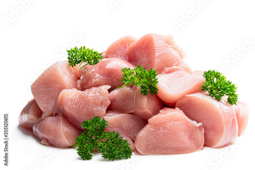 Raw chicken breast fillet chunks with parsley herb isolated on white