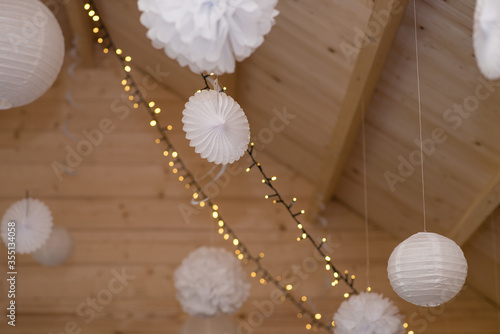 Paper lanterns hanging from wooden roof