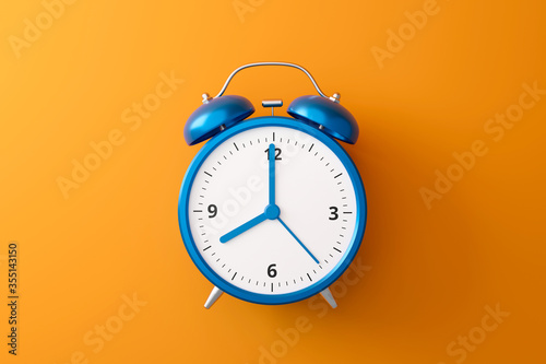 Blue alarm clock on orange background with complementary color and retro style. Classic analog clock and blank space. 3D rendering.