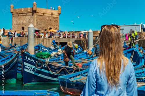 Girl in the port of Essaouira. The famous blue boats.