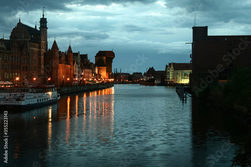 Waterfront of the Martwwa Wisla Vistula river with Medieval houses of the baltic architecture in the Srodmiescie district of Gdansk at night