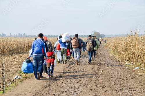 Refugees and migrants walking on fields. Group of refugees from Syria and Afghanistan on their way to EU. Balkan route. Thousands of refugees on border between Croatia and Serbia in autumn 2015.