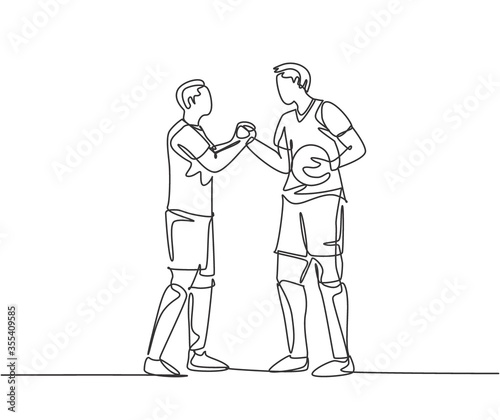 Continuous line drawing of two football player bring a ball and handshaking to show sportsmanship before starting the match. Respect in soccer sport concept. One line drawing vector illustration