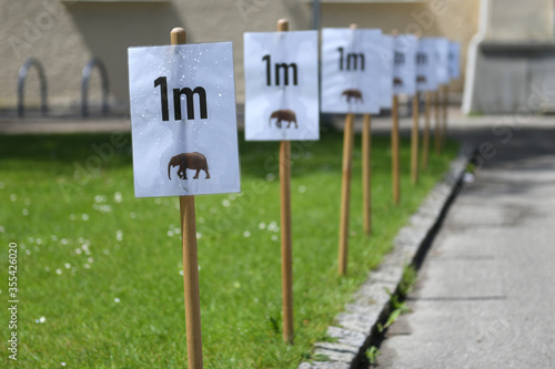 Corona-Krise - Tafeln mit Abstandsbestimmung von einem Meter vor einer Volksschule in Wels - Corona crisis - boards with distance determination of one meter in front of an elementary school in Wels