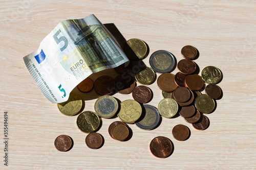 Dinero. Monedas de euro, de céntimo y billete de 5 euros.