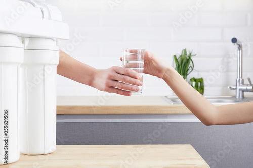 Female Hand giving a glass of clean water. Purified water and healthy life concept.