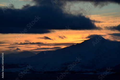colorful dawn sky over snowy mountain and sea