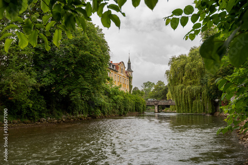 Famous old stone bridge with engraved city arms over the river Amper in the bavarian town Fuerstenfeldbruck on cloudy overcast day