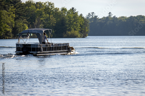 pontoon boat with canopy on lake