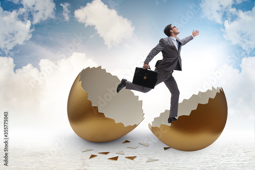 Businessman breaking out of golden egg