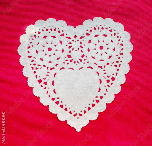 White doily hearts on red background