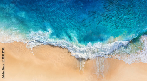 Beach and waves as a background from top view. Blue water background from drone. Summer seascape from air. Travel image