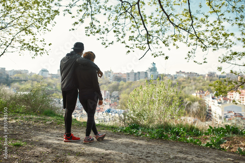 Full length shot of young fitness couple in sportswear looking at amazing view of city after training together outdoors