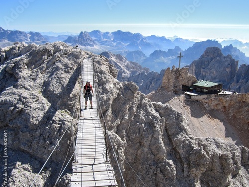 Escursionista sul ponte di montagna in estate, concetto di isolamento sociale e distanza