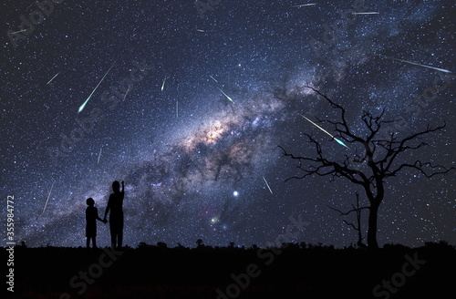 Dzieci obserwujące rój meteorów potocznie zwany deszczem spadających gwiazd, oraz piękna Droga Mleczna z wyraźnie widocznym centrum naszej galaktyki - Children observing a swarm of meteors