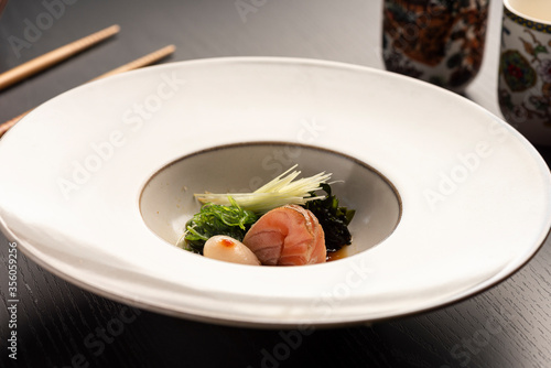 sashimi japanese dish with vegetables on white ceramic