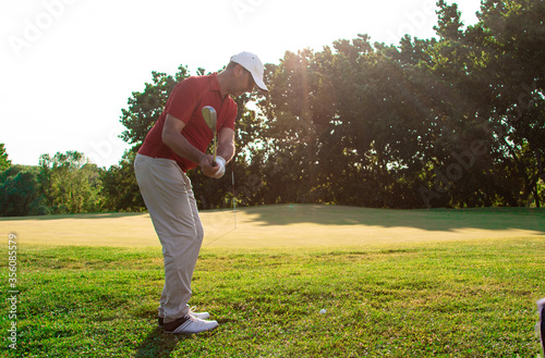 golfer hit the golf ball near the green - adult man play golf in summer