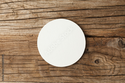 Beer coaster mockup on wooden background.