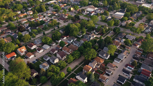 Aerial view of american suburb at summertime. Establishing shot of american neighborhood. Real estate, residential houses. Drone shot, from above