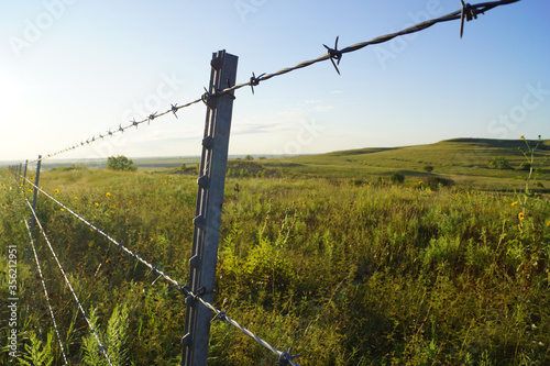 A barbed wire fence separates ranch properties in the Flint Hills of rural Kansas.