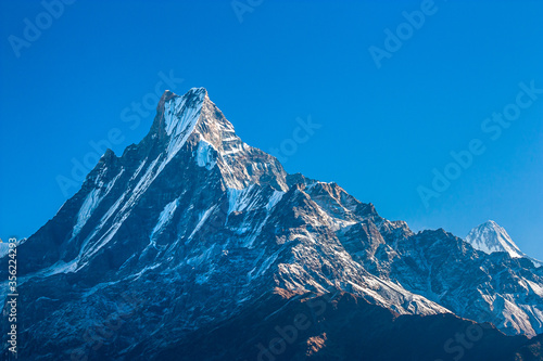 Top of the mountain peak summit in clear blue sky. Himalayas 