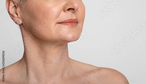Skin Lifting. Mature woman with smooth skin over light background, cropped image