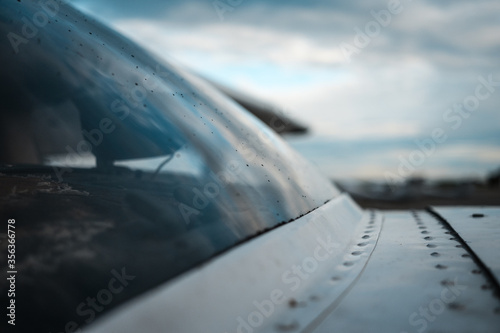 Rain drops on the windshield of small general aviation airplane.