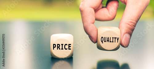 Price versus Quality. The cube with the word "quality" is selected by a hand.