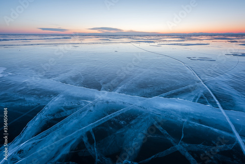 Early morning on the ice of lake Baikal against the background of mountains and ice