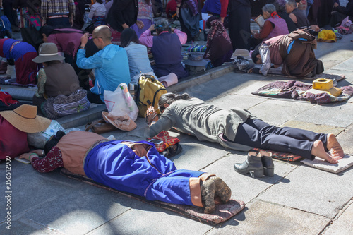 People praying in prostration in front of Jokhang temple in Lhasa on Barkhor square, Tibet