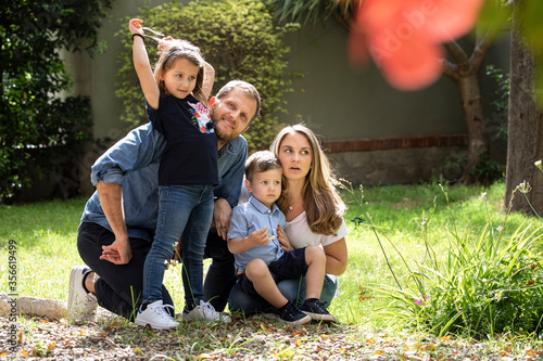 Bellissima famiglia composta da 2 genitori e figli si raduna felice in gruppo nel giardino di casa