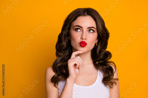 Closeup photo of pretty intelligent wavy lady red lips look thoughtful empty space clever idea hand on chin wear white casual tank-top isolated bright yellow color background