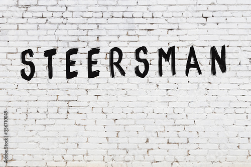 Word steersman painted on white brick wall