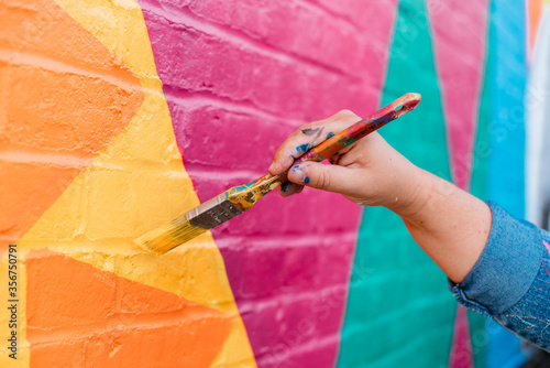 Artist painting a wall with a brush