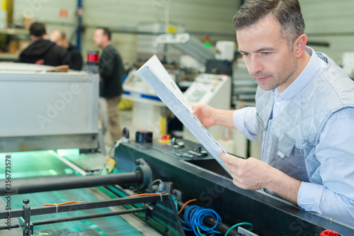 worker next to the printing machine inputs