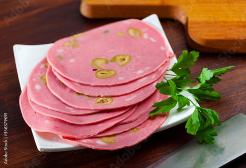 Close-up of sliced mortadela sausage with olives