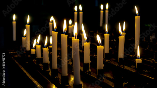 Płonące świece stojące na świecznikach w kościele