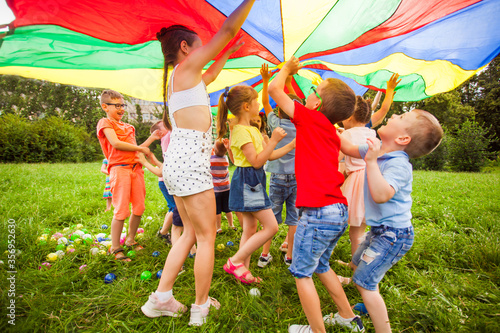 Happy kids under colorful canopy. Summer camp activities