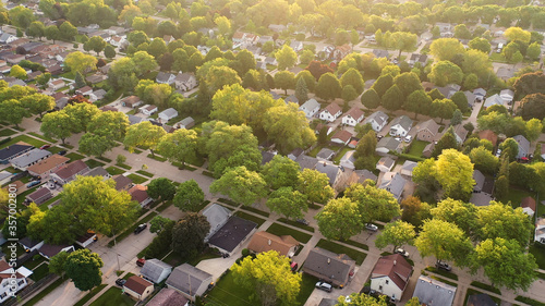 Aerial view of american suburb at summertime. Establishing shot of american neighborhood. Real estate, residential houses. Drone shot, from above