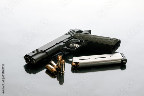 Hefty 1911 semi automatic handgun unloaded next to 8 round magazine and 4 loose hollow point bullets is a good choice for home protection from crimminals.