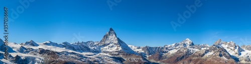 Stunning panorama view of the famous Matterhorn, Weisshorn and Pennine Alps on Swiss Italien border on sunny autumn day with snow and blue sky, from Gornergrat station, Valais, Switzerland