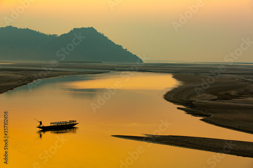 sunset on the river,silhouette of a man rowing a boat,Mayong, Brahmaputra river ,Assam,India